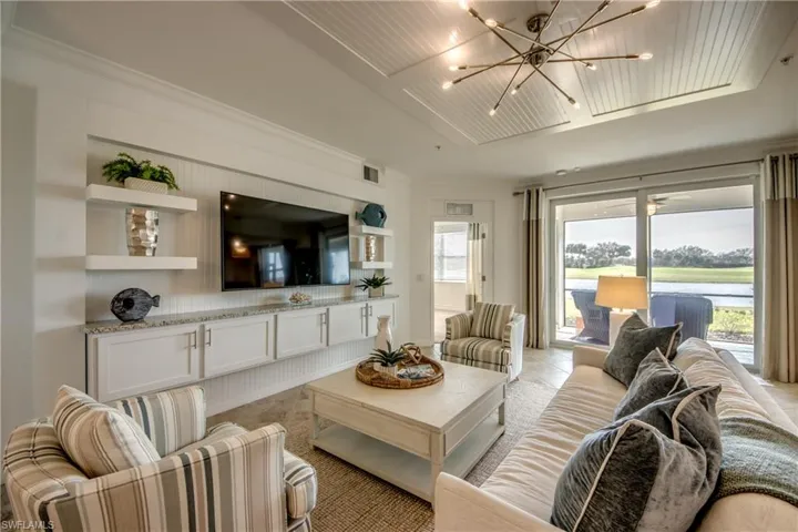 Living room featuring an inviting chandelier, light tile patterned flooring, a tray ceiling, and wood ceiling