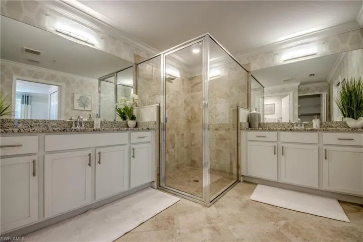 Bathroom featuring vanity, an enclosed shower, and ornamental molding
