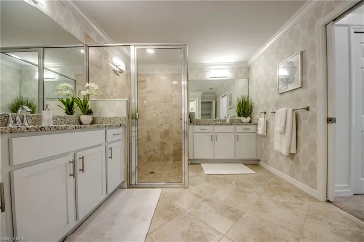 Bathroom featuring vanity, crown molding, and an enclosed shower