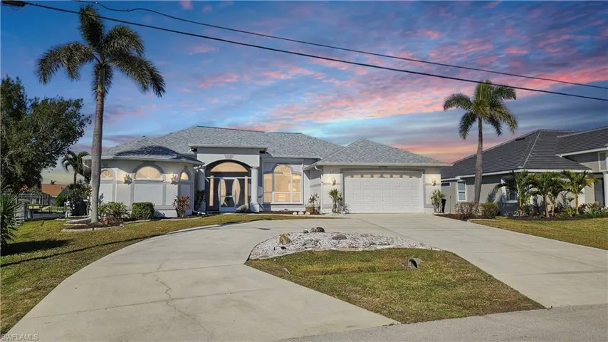 View of front of house featuring a garage and a lawn