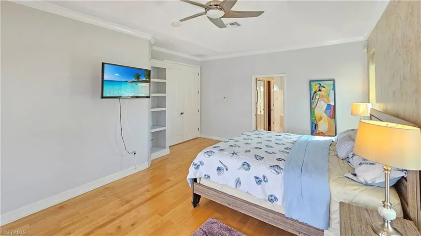 Bedroom featuring ornamental molding, wood-type flooring, and ceiling fan