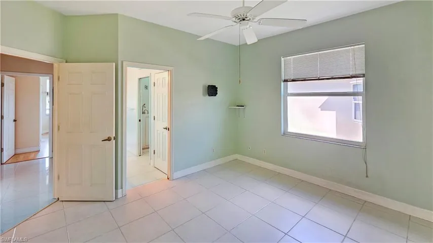 Unfurnished bedroom featuring light tile patterned floors and ceiling fan