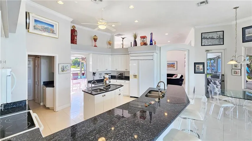 Kitchen featuring white cabinetry, sink, paneled refrigerator, and a center island