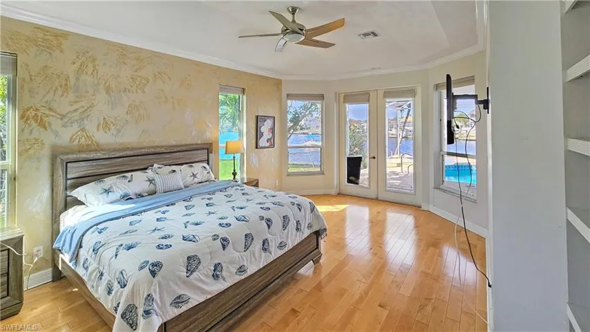 Bedroom featuring crown molding, multiple windows, light hardwood / wood-style flooring, and access to outside