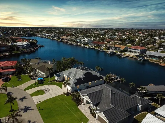Aerial view at dusk featuring a water view