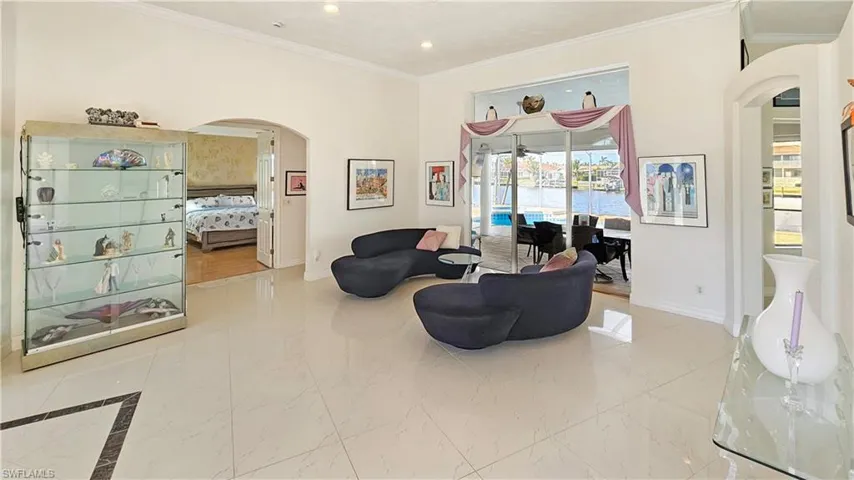 Living room with crown molding and a water view