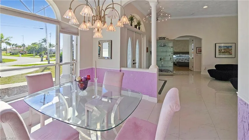 Dining area with a notable chandelier, ornamental molding, and ornate columns