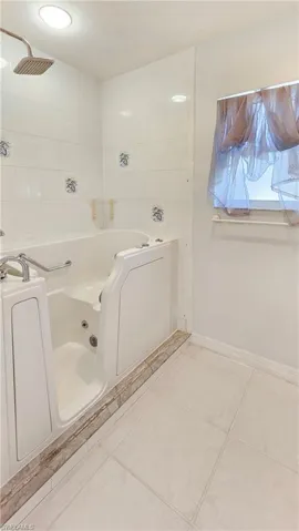 Bathroom featuring tile patterned flooring and a bath