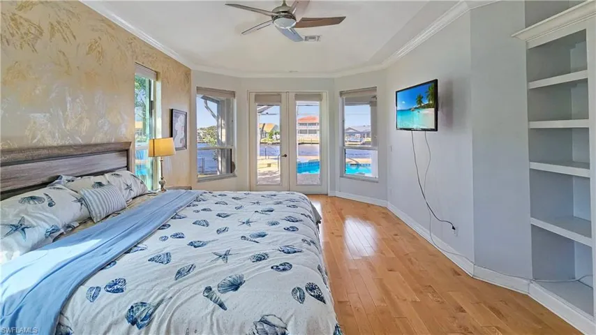 Bedroom featuring ceiling fan, ornamental molding, light wood-type flooring, and access to outside