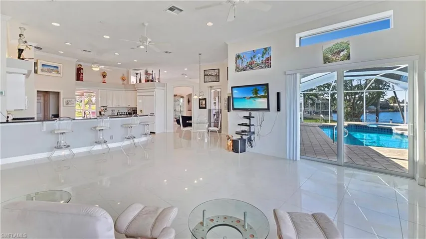 Living room with ornamental molding and ceiling fan
