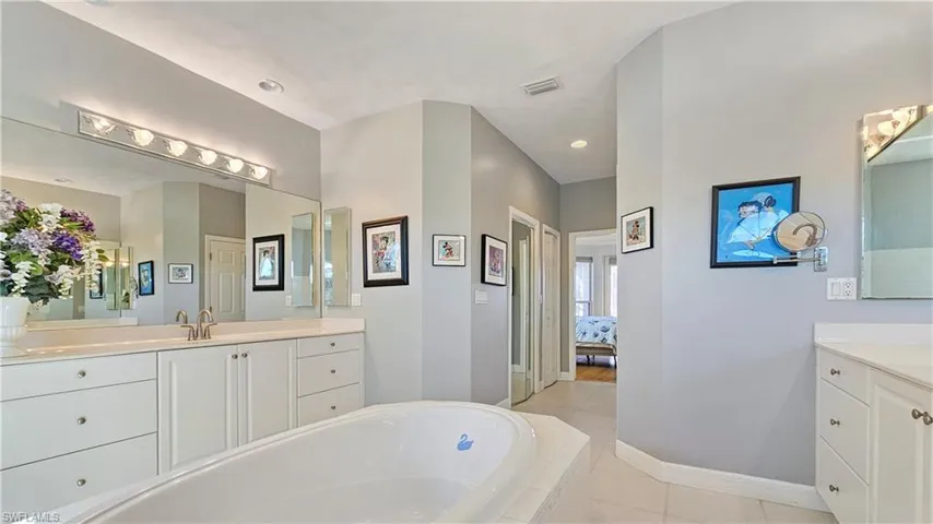 Bathroom featuring vanity and tiled bath