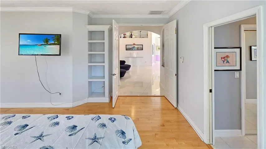 Bedroom with crown molding and wood-type flooring