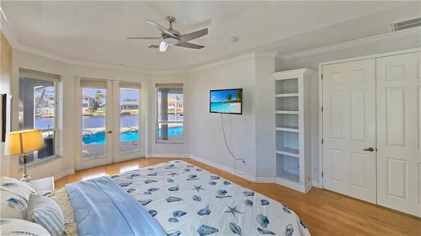 Bedroom featuring french doors, access to outside, ornamental molding, ceiling fan, and light hardwood / wood-style floors