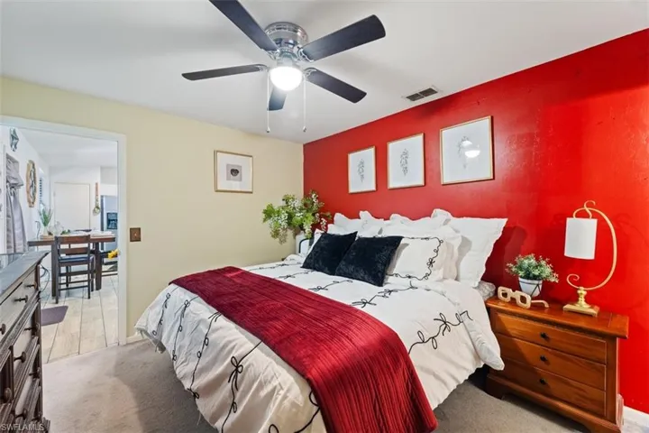 Bedroom with light colored carpet and a ceiling fan