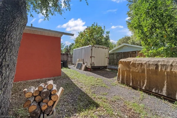 Fenced backyard featuring a storage shed