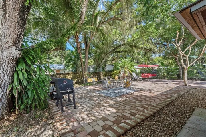 Fenced backyard featuring a patio and grilling area