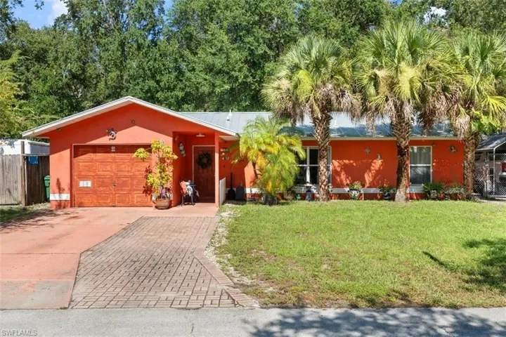 View of front of property featuring a garage, concrete driveway, and stucco siding