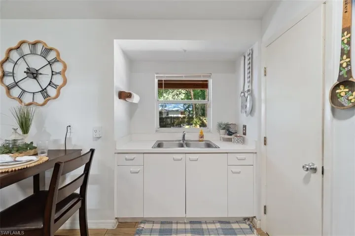 Bar area featuring white cabinets, light countertops, and light wood-type flooring