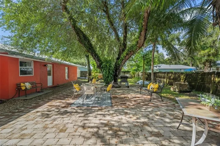 Fenced backyard with a patio area, outdoor dining space, and a grill