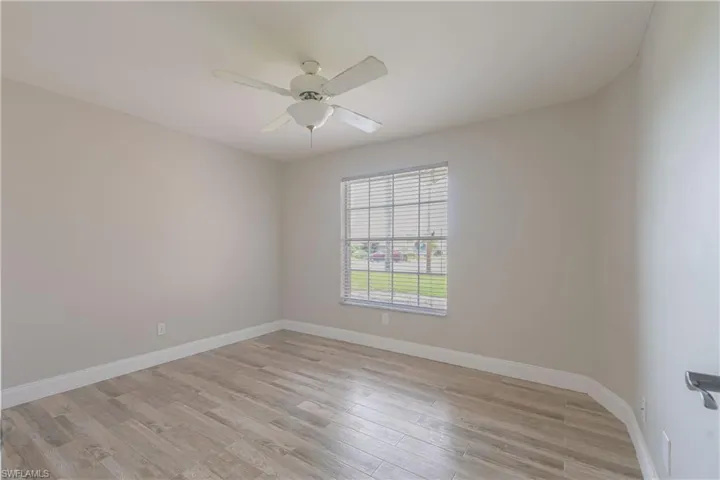 Unfurnished room with light wood-type flooring, ceiling fan, and baseboards