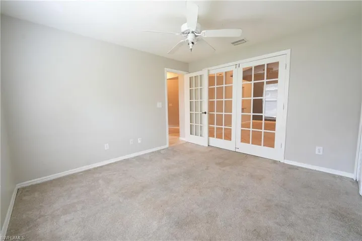 Spare room featuring french doors, a ceiling fan, carpet, and baseboards