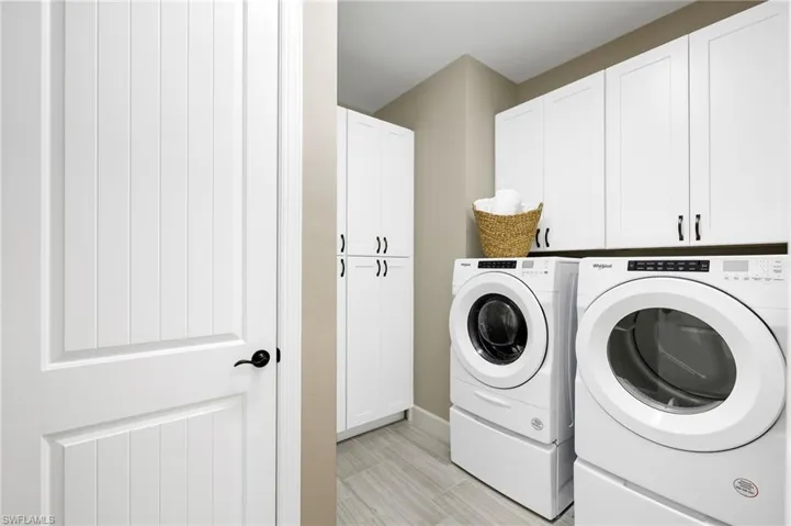 Separate laundry with ample storage.
