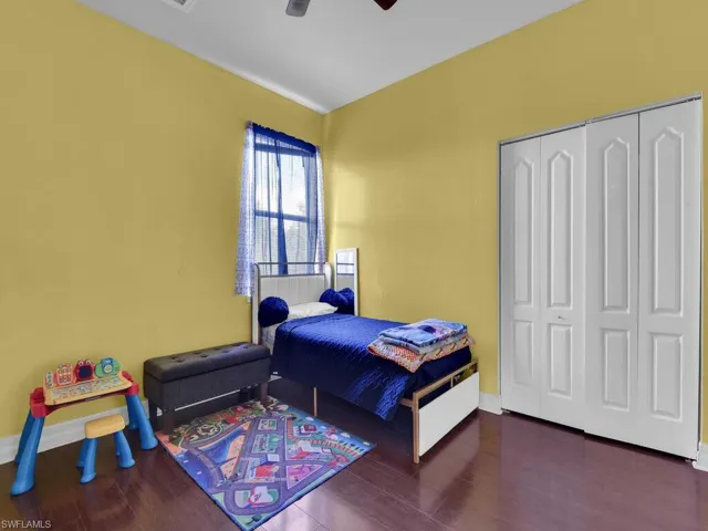 Bedroom with ceiling fan, a closet, baseboards, and wood finished floors