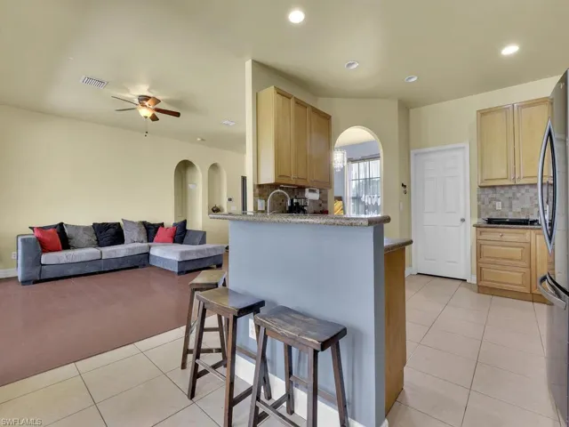 Kitchen with visible vents, freestanding refrigerator, arched walkways, and light tile patterned floors