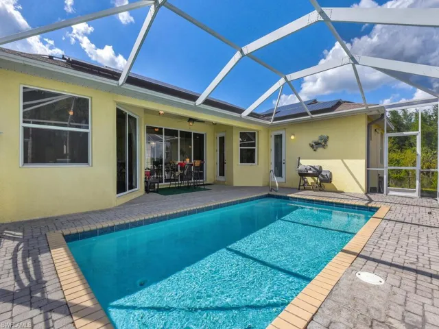 Pool with a patio area, ceiling fan, and glass enclosure