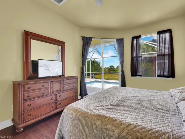 Bedroom featuring access to exterior, baseboards, and dark wood finished floors
