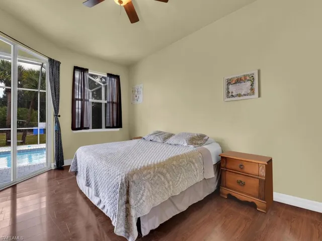 Bedroom featuring a ceiling fan, access to outside, baseboards, and dark wood-style floors
