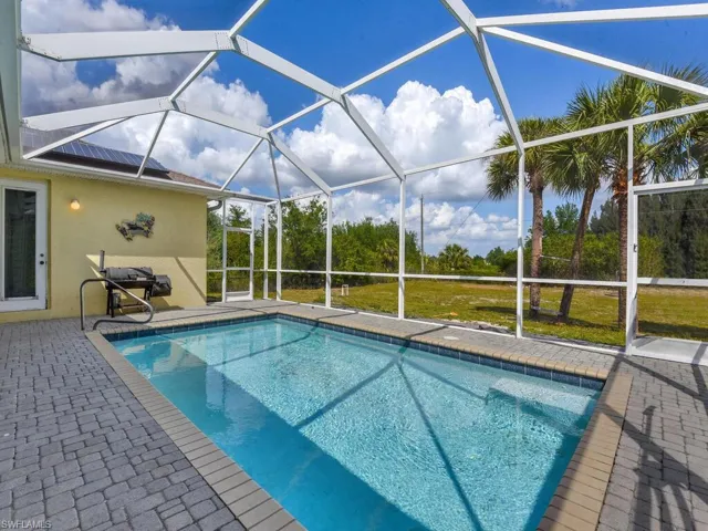 Pool featuring a patio area and glass enclosure