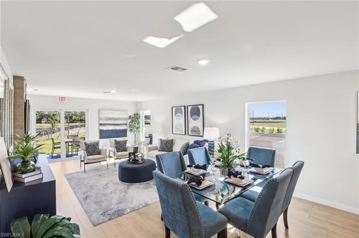 Model home. Dining space with light wood finished floors and plenty of natural light