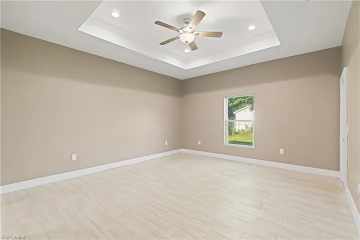 Spare room with ceiling fan and a tray ceiling