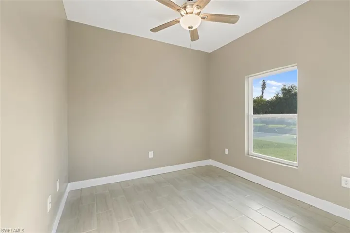 Spare room with light hardwood / wood-style floors, a wealth of natural light, and ceiling fan