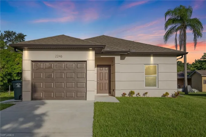 View of front of house with a garage and a lawn