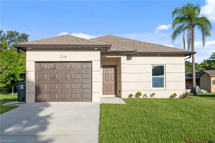 View of front of home with a garage and a front yard