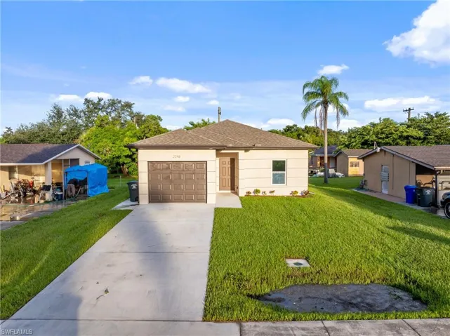 Ranch-style house featuring a garage and a front yard