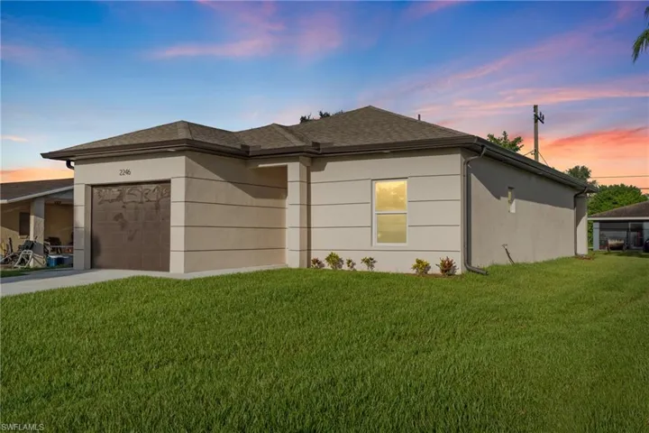 View of front of property featuring a garage and a lawn