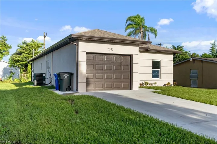 Garage with central air condition unit and a lawn