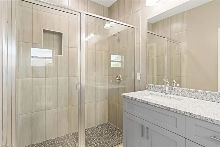 Bathroom with a shower with shower door and vanity