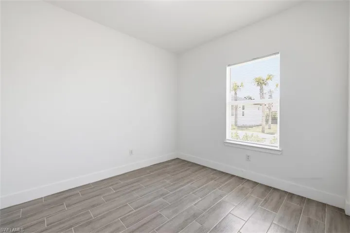 Guest Room Neutral tone walls with wood-finish tile flooring