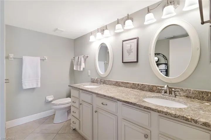 Primary Bathroom with coastal inspired double vanity and updated light fixtures