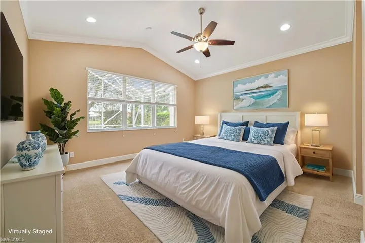Bedroom featuring ceiling fan, crown molding, light colored carpet, and vaulted ceiling