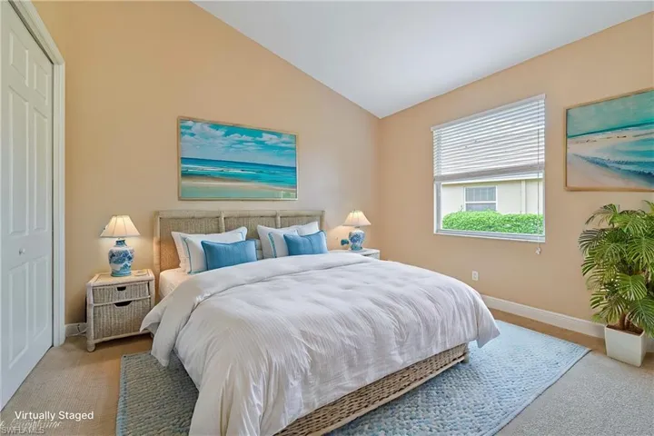 Bedroom with light carpet, a closet, and lofted ceiling