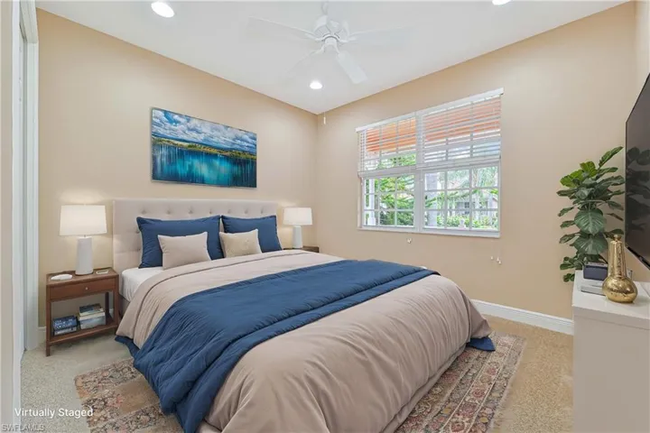 Carpeted bedroom featuring ceiling fan