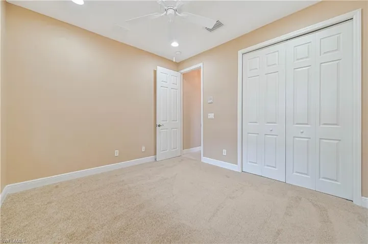 Unfurnished bedroom featuring ceiling fan, a closet, and carpet floors