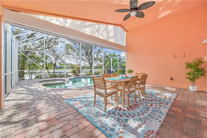 View of patio featuring ceiling fan, a lanai, and a pool with hot tub
