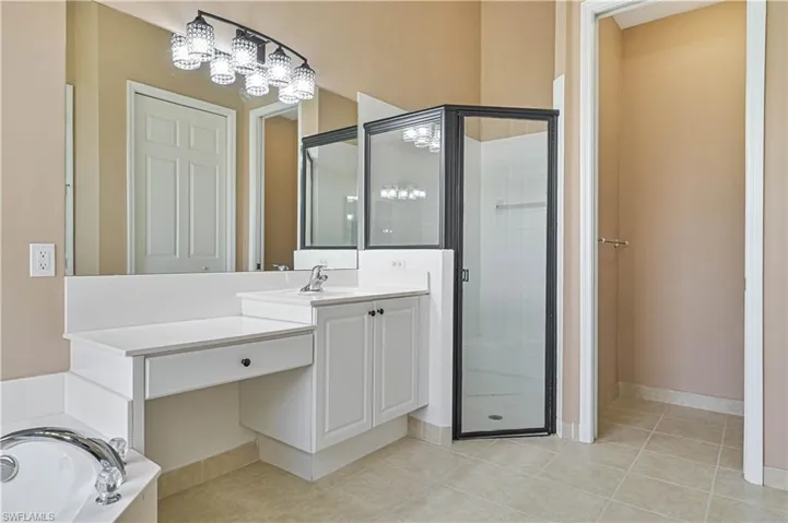 Bathroom with tile patterned floors, vanity, and independent shower and bath
