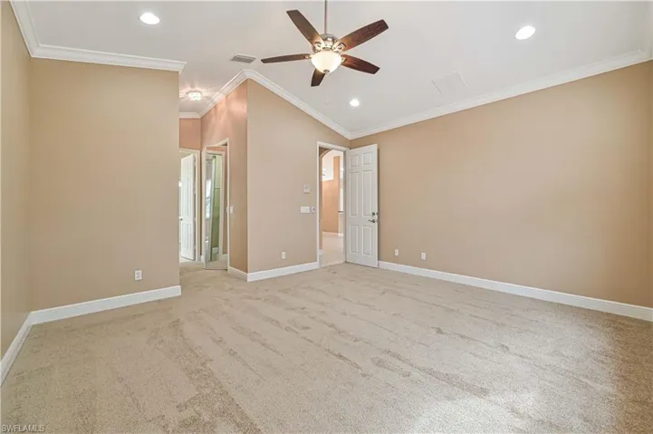 Unfurnished room featuring crown molding, ceiling fan, light carpet, and lofted ceiling